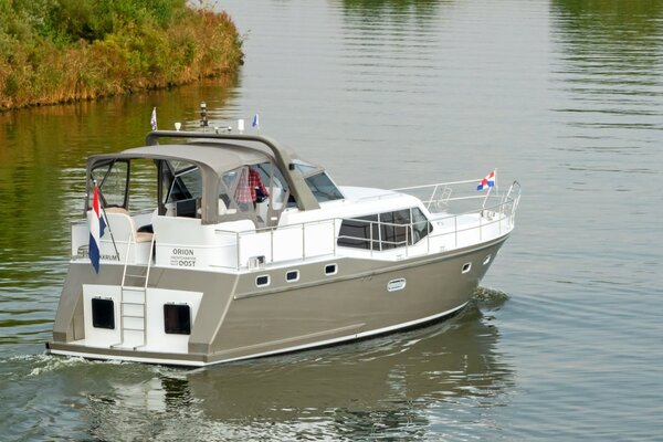 Overhead view of a motor yacht sailing along a waterway in Friesland. 